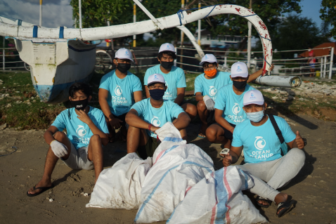 Volunteers picking up litter by the ocean
