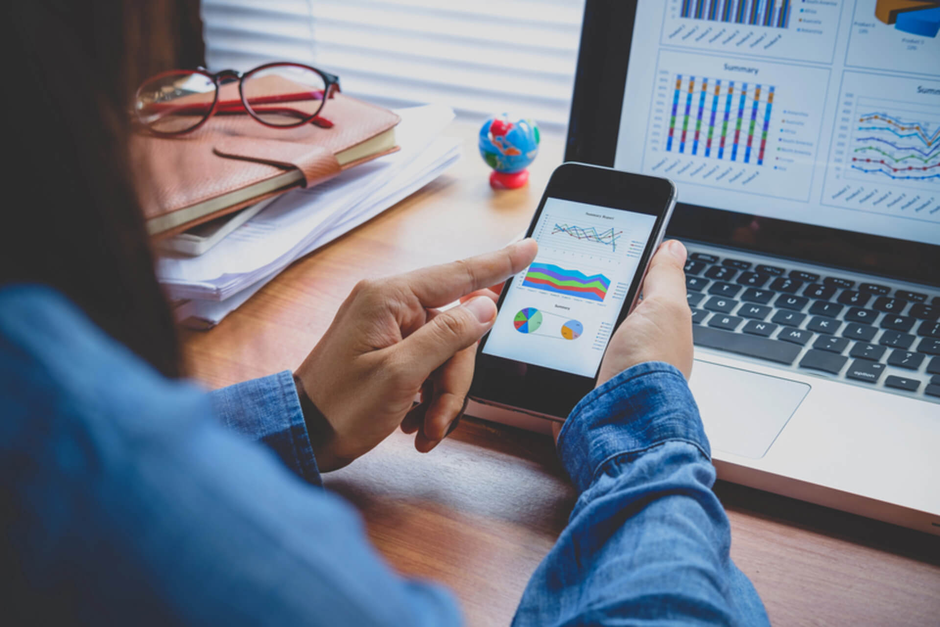 woman looking at financial analysis on mobile phone