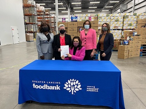 Organizers with Helping Women Period join Michigan Gov. Gretchen Whitmer as she signs into law a repeal of the state's tampon tax.