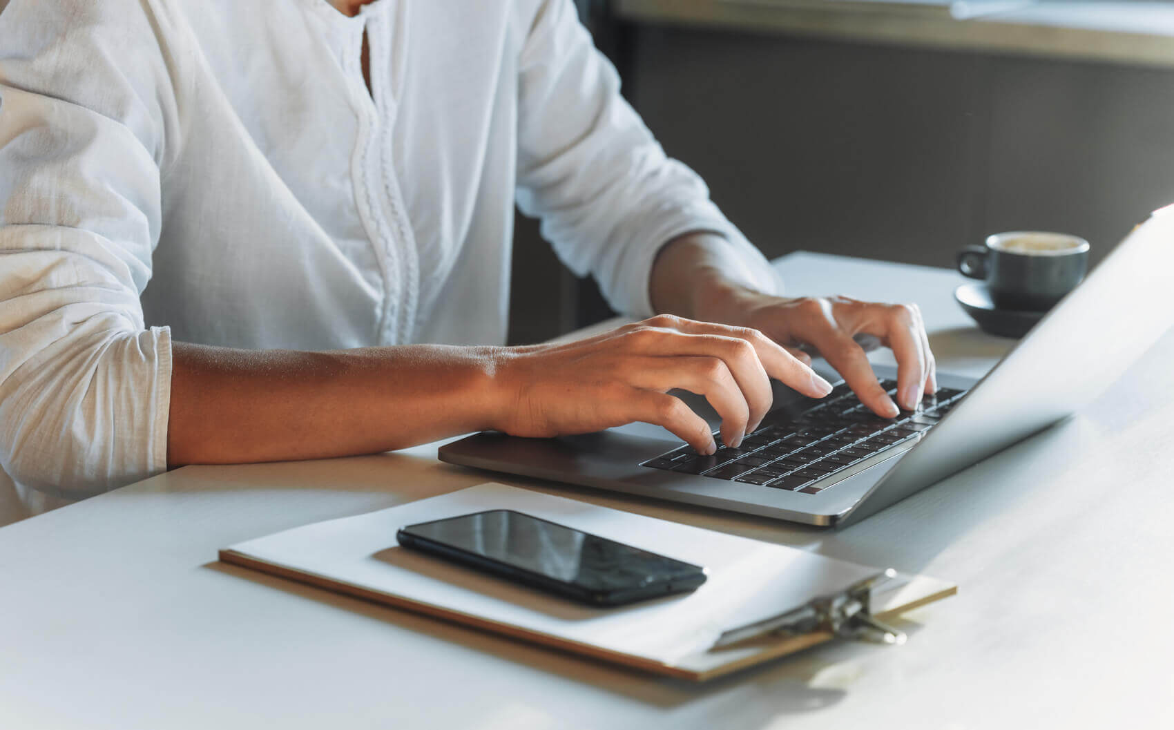 A person’s hands typing on a laptop